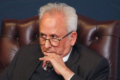 Older man in suit sitting thoughtfully in leather chair