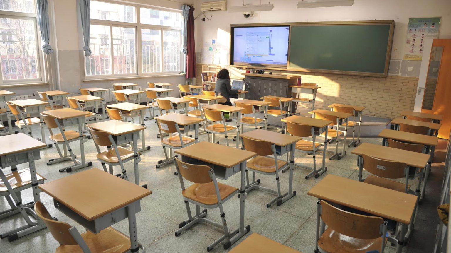 Empty classroom with desks and teacher at front