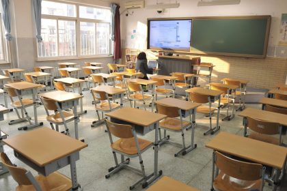 Empty classroom with desks and teacher at front