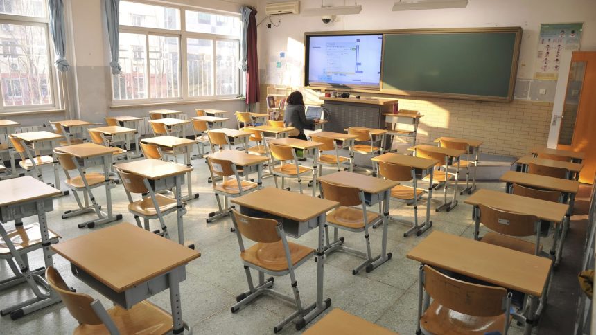 Empty classroom with desks and teacher at front