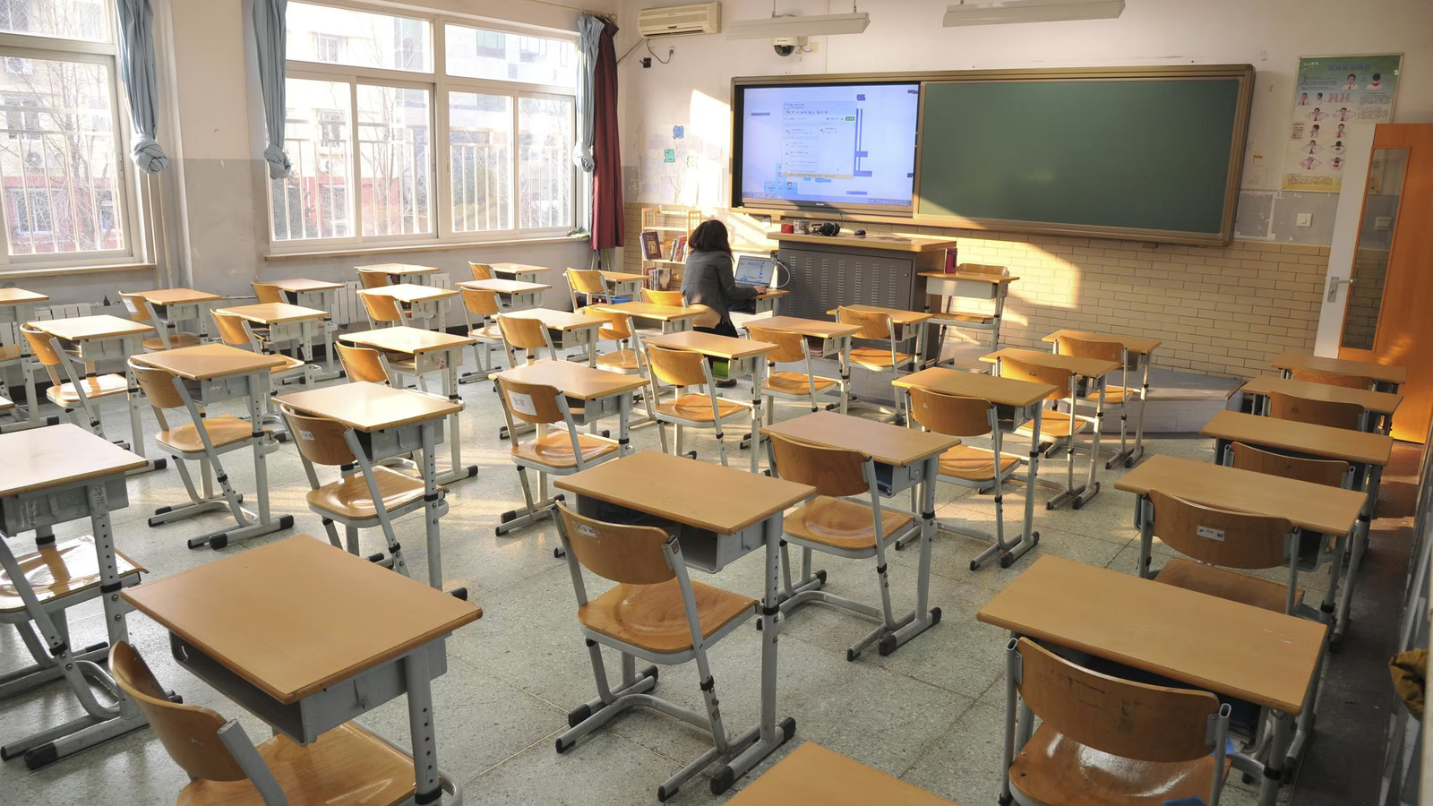 Empty classroom with desks and teacher at front