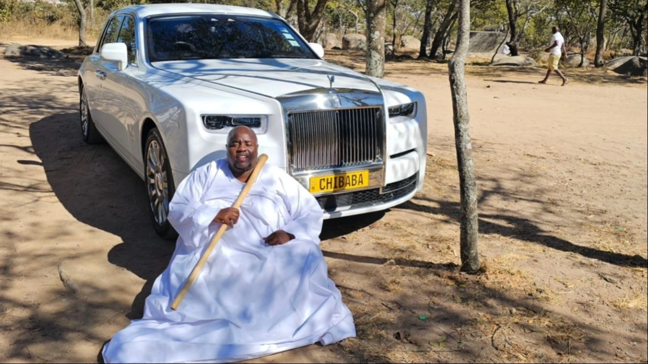 Man in white robe before luxury car