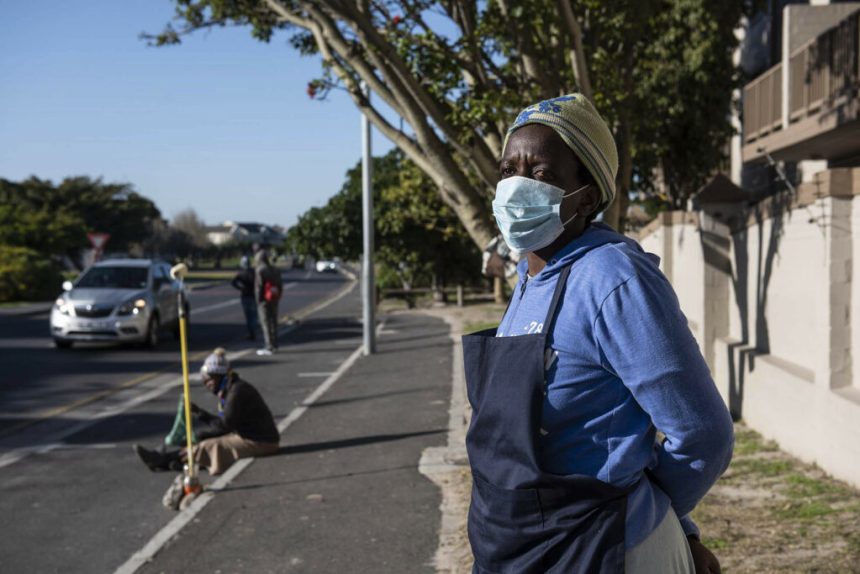 Masked woman standing on suburban roadside