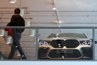 BMW X6 M in modern showroom behind glass