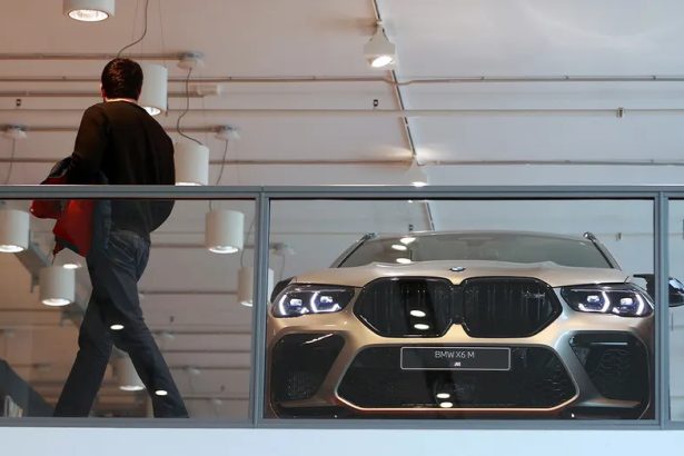 BMW X6 M in modern showroom behind glass