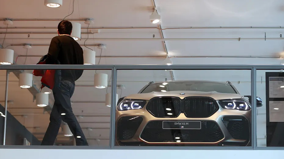 BMW X6 M in modern showroom behind glass
