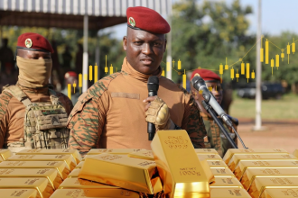 Soldier speaking behind stacked gold bars display
