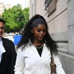 Woman walking outside courthouse with lawyer behind her