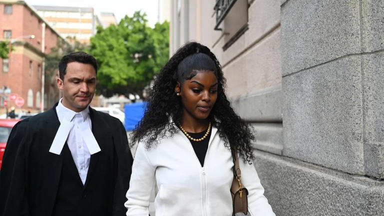 Woman walking outside courthouse with lawyer behind her