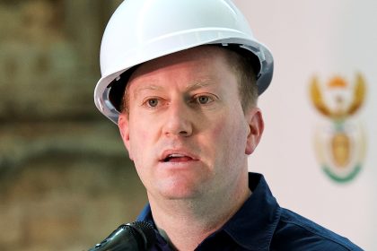 Man in hard hat speaking at podium