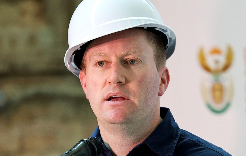 Man in hard hat speaking at podium