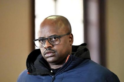 Man wearing glasses and dark jacket indoors