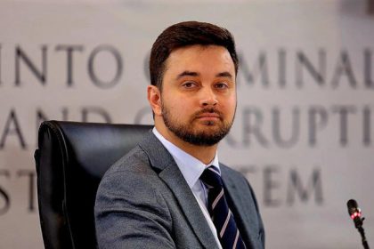 Man in suit seated at commission hearing