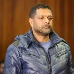 Man standing in courtroom with microphone nearby