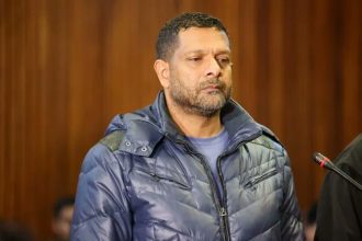 Man standing in courtroom with microphone nearby
