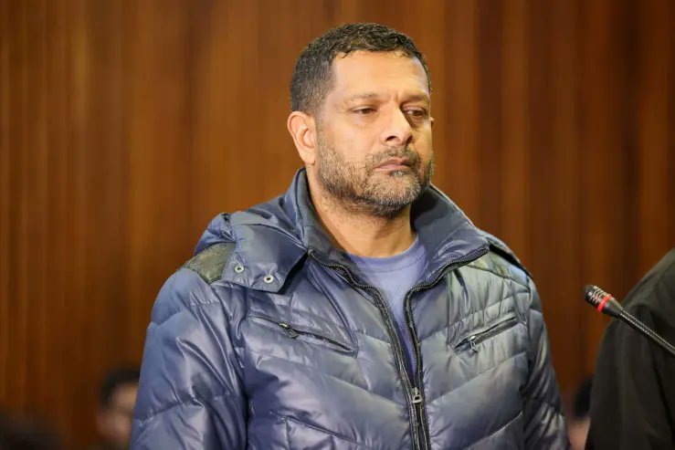 Man standing in courtroom with microphone nearby