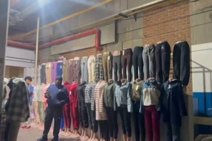 Clothing display with trousers and outfits on wall