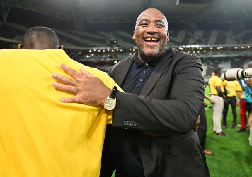 Man in suit hugging person on stadium field