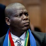 Man in suit wearing South African flag scarf