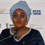 Woman speaking at tourism press briefing podium