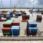 Shipping containers stacked at busy river port