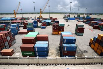 Shipping containers stacked at busy river port