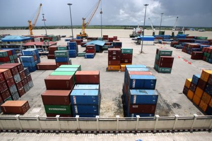 Shipping containers stacked at busy river port