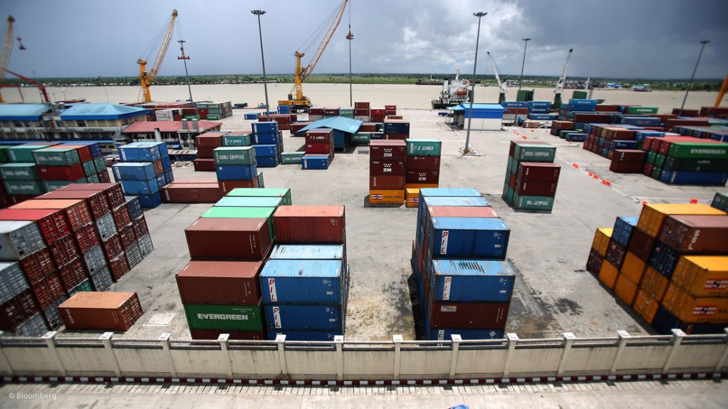 Shipping containers stacked at busy river port