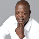Man in white shirt posing with hand on chin