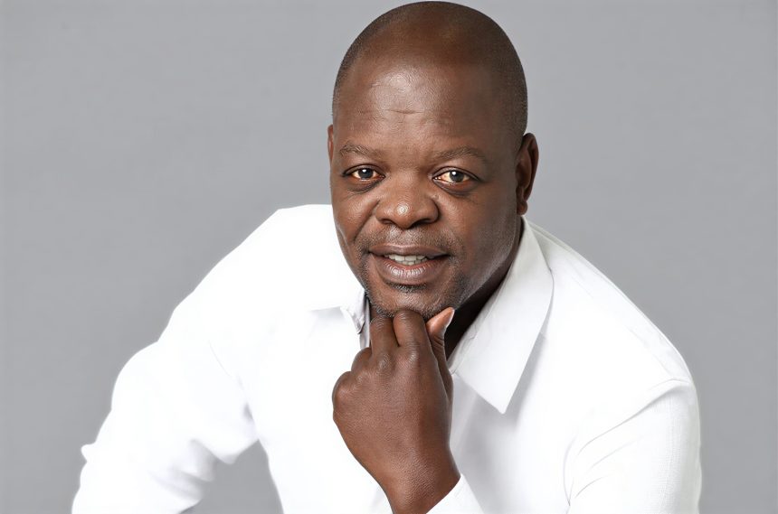 Man in white shirt posing with hand on chin