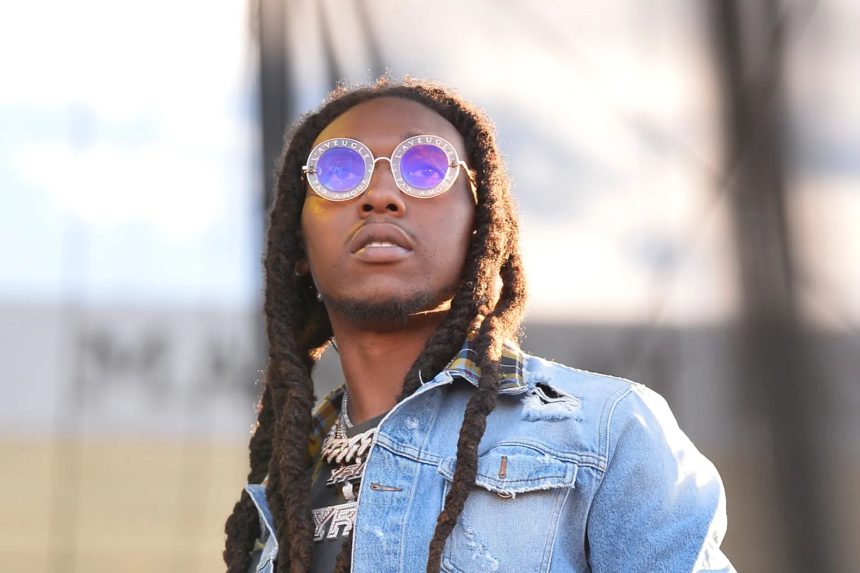 Man with dreadlocks wearing round sunglasses outdoors