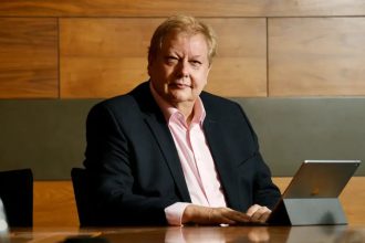 Businessman seated at table using tablet in office