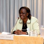 Smiling woman speaking at a conference podium