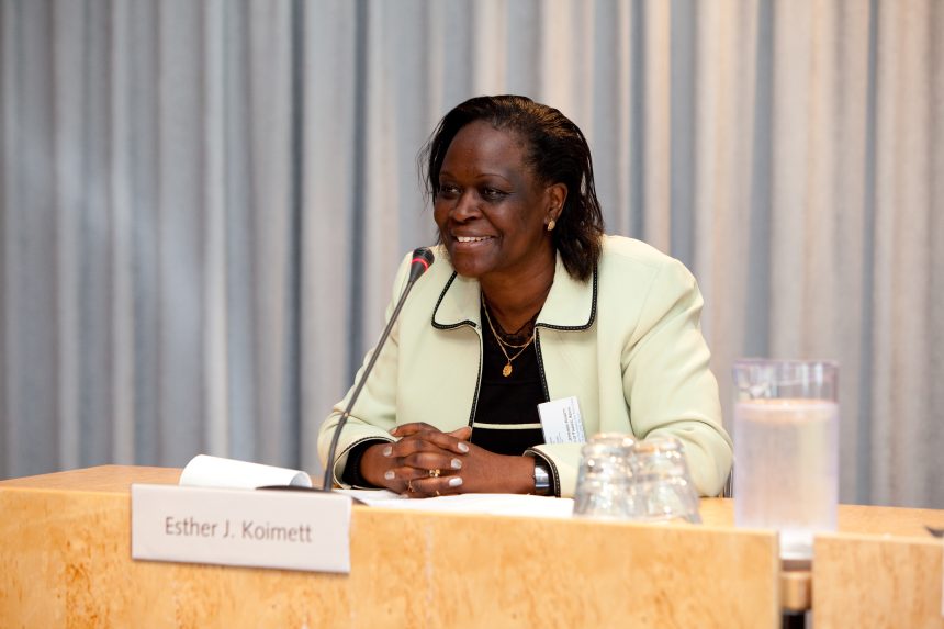 Smiling woman speaking at a conference podium