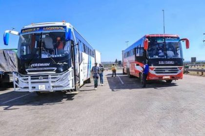 Two passenger buses stopped on a sunny highway