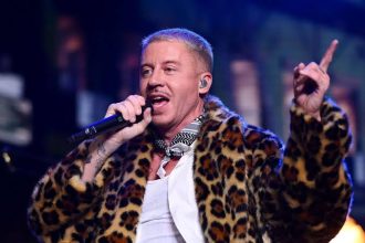 Singer performs onstage in a leopard-print coat