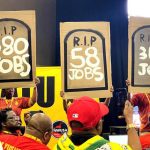 Members of the South African Clothing and Textile Workers Union hold up placards showing the number of jobs that could be lost by 2030 in the clothing, textile and manufacturing industries. (Photo: Naledi Mashishi)