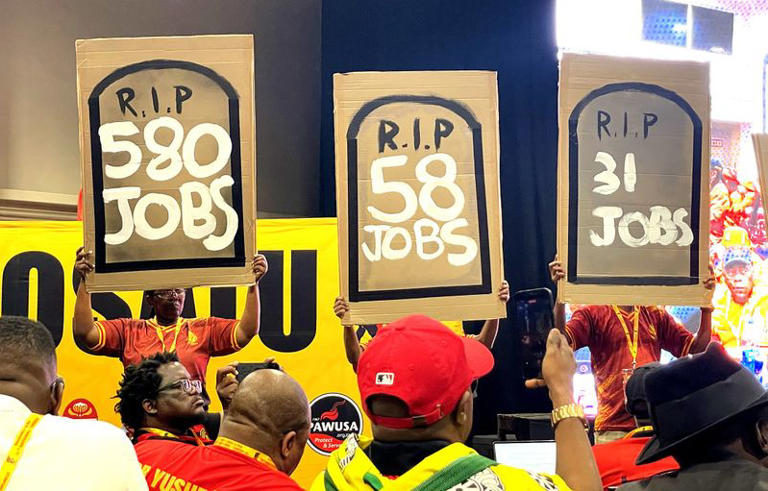 Members of the South African Clothing and Textile Workers Union hold up placards showing the number of jobs that could be lost by 2030 in the clothing, textile and manufacturing industries. (Photo: Naledi Mashishi)